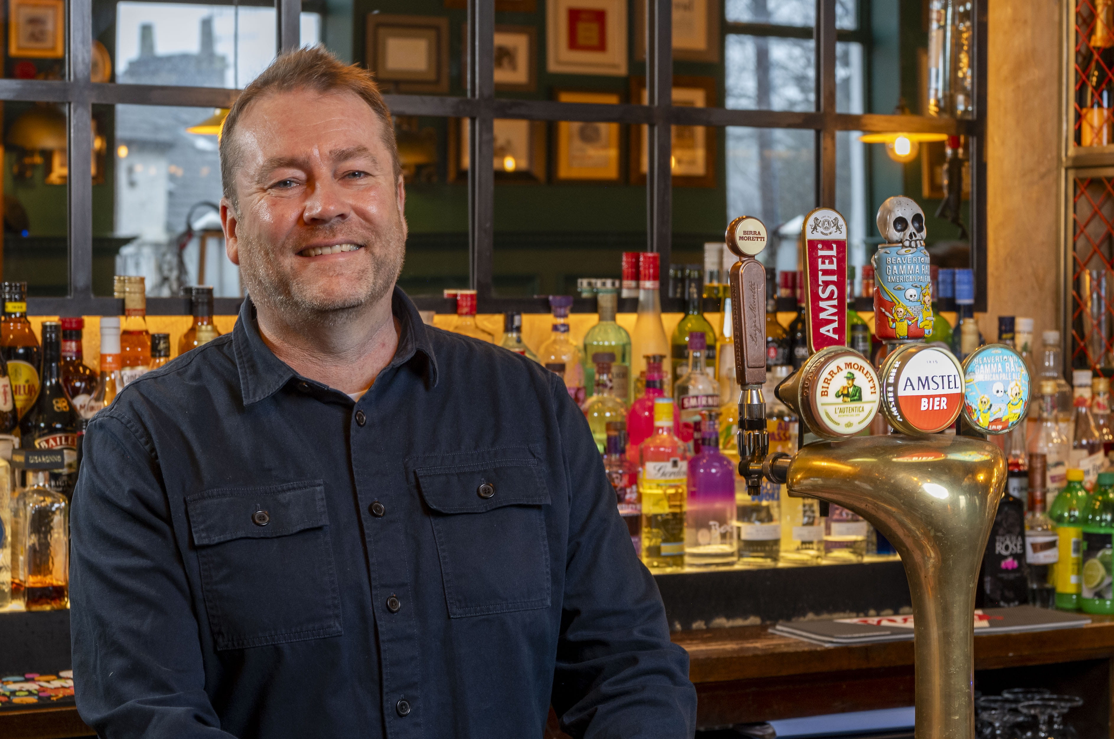 Image of a man standing in front of a bar