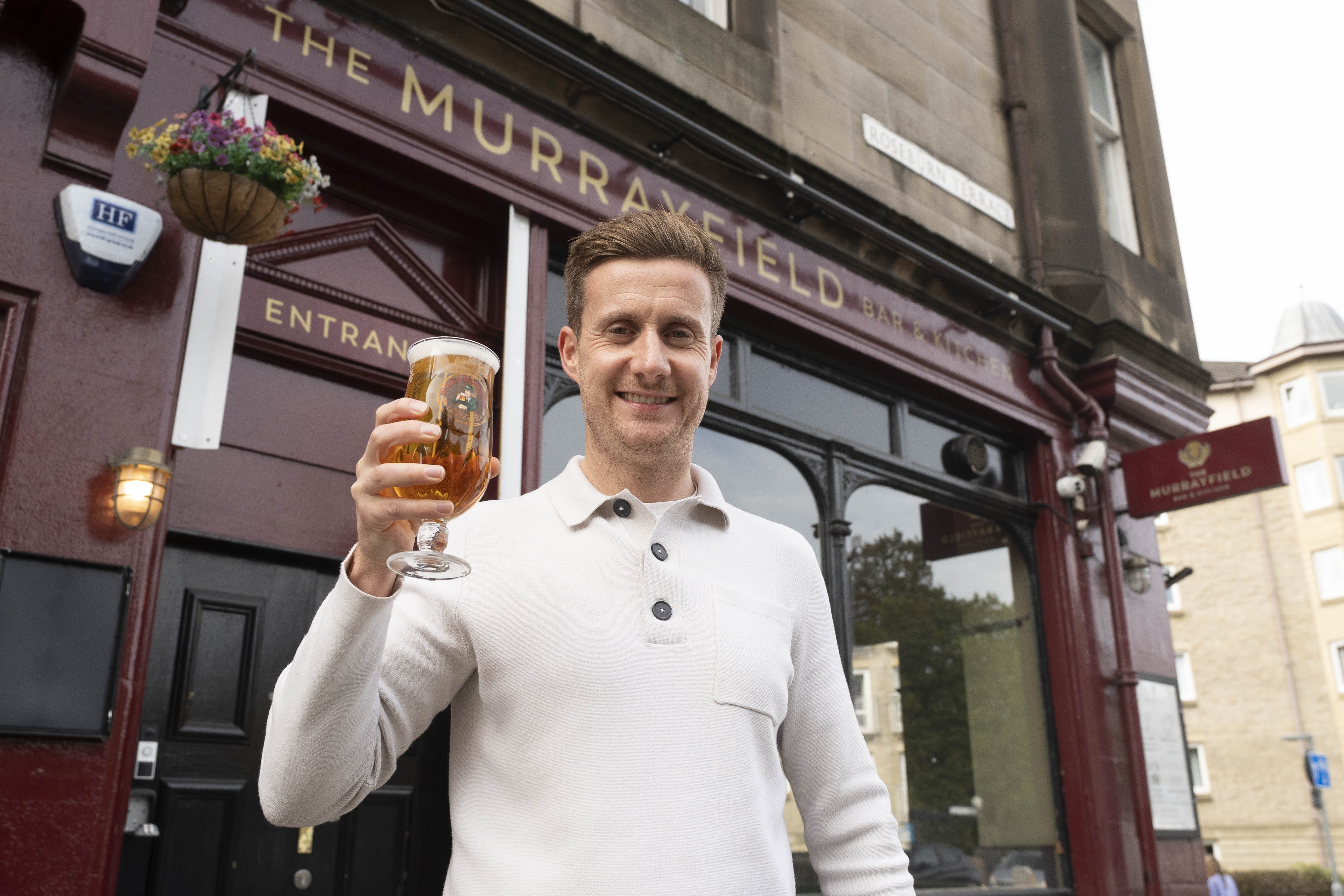 The Murrayfield Bar with licensee standing outside with pint in his hand