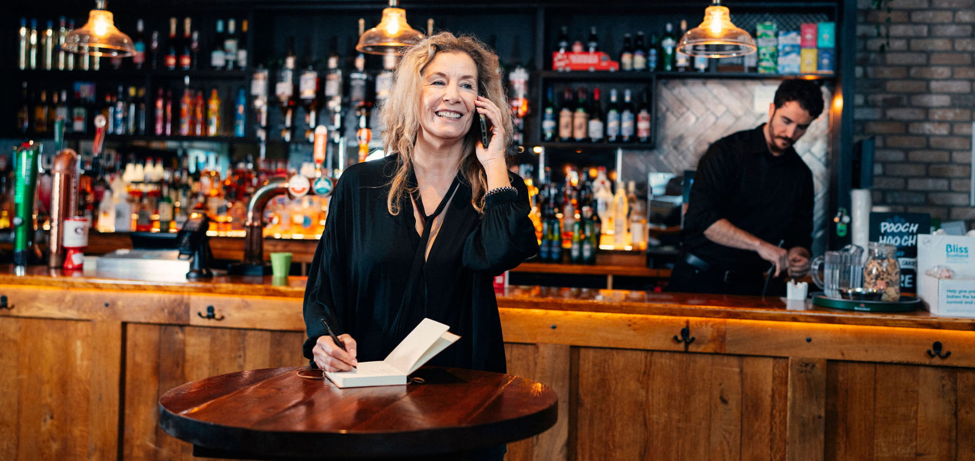 Woman running a pub taking a telephone call