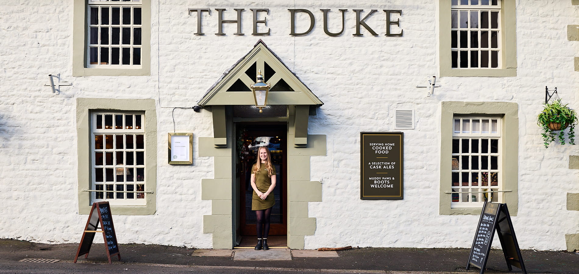 Woman standing outside her pub