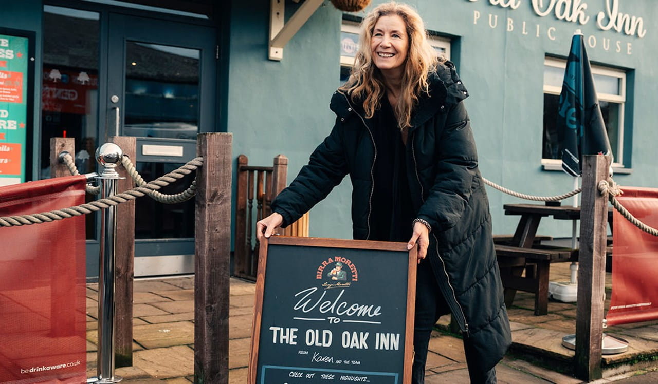 Woman opening up her pub setting out advertising board