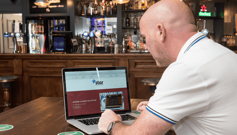 man using a laptop in a pub