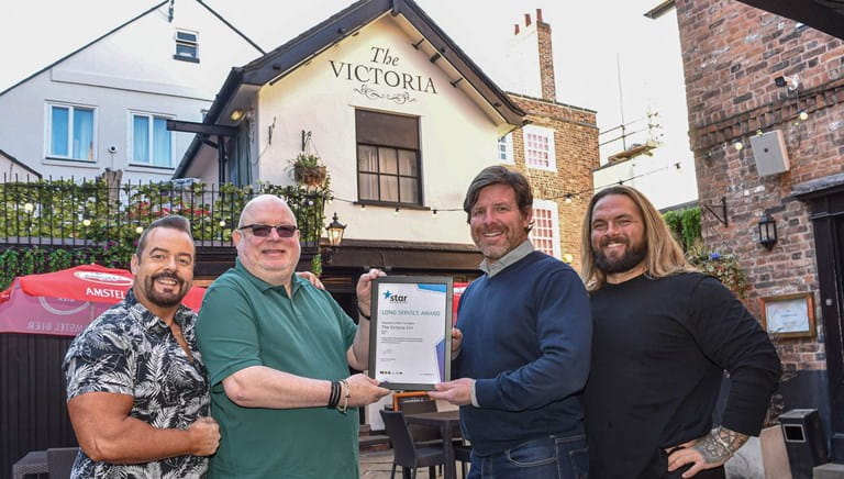 An award being held up outside the Victoria