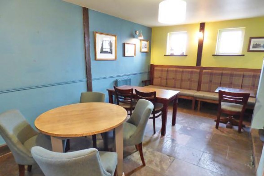 Round table with chairs with cloth benches at rear wall