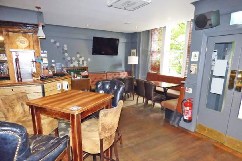 Seating area next to main bar with chairs and bench seats