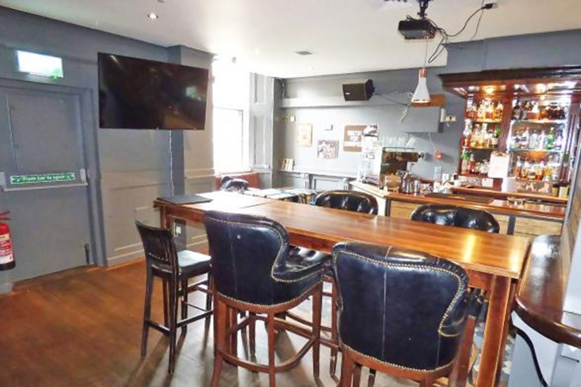 Sitting area with high table and chairs with TV