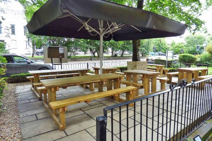 Outdoor seating area with picnic tables and large parasol